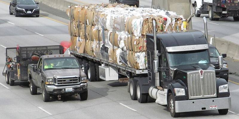 A flatbed trailer load strapped down on a highway